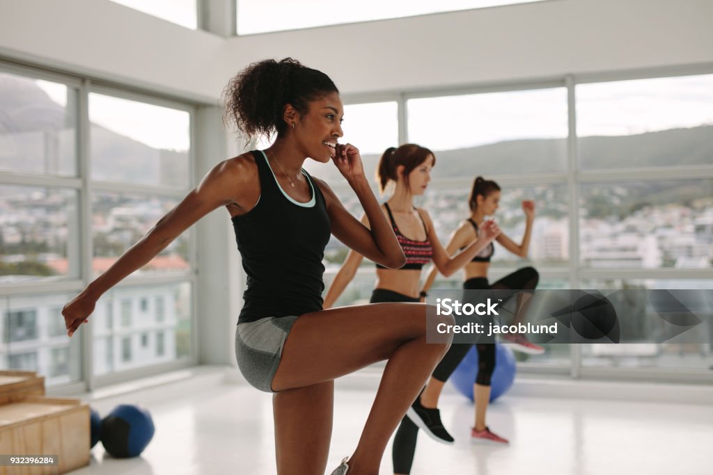 Multi exercícios de mulheres étnicas nas aulas de ginástica - Foto de stock de Aeróbica royalty-free