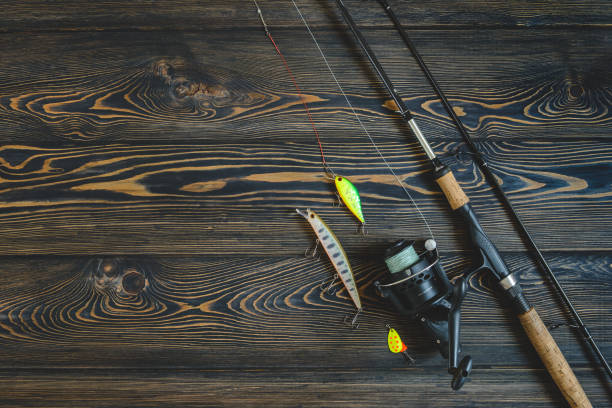 istock fishing tackle on a wooden table. toned image 932408672