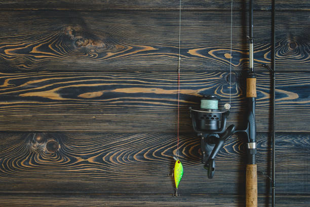 istock fishing tackle on a wooden table. toned image 932408770