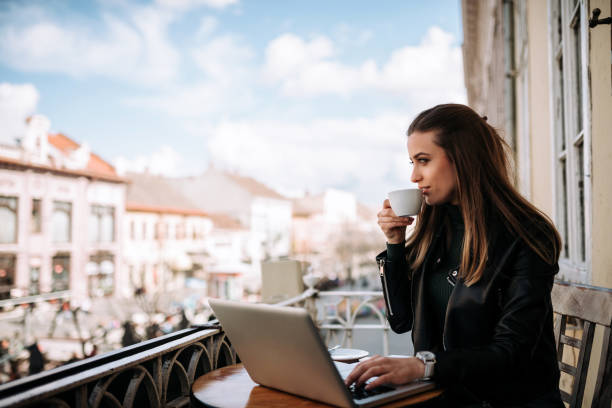 istock Woman drinking coffee on the terrace wihle working on a laptop. 932409048