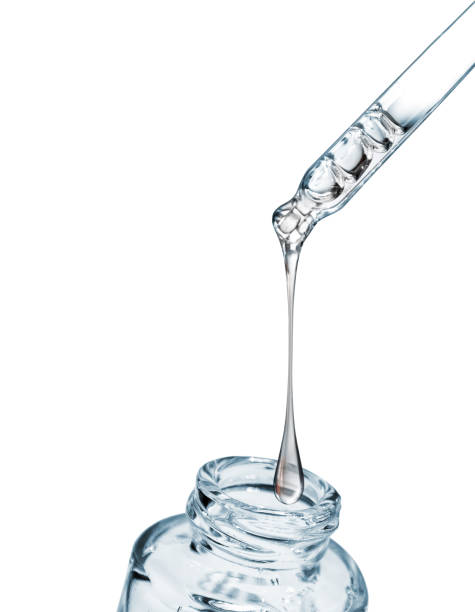 istock Drop falls from a pipette into a cosmetic bottle close-up, isolated on white background 932415566