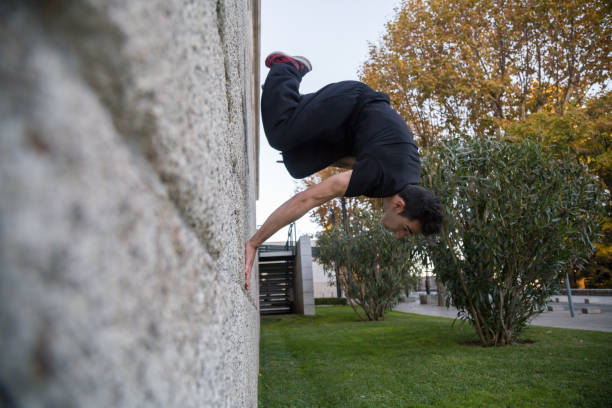 istock Young man doing an amazing parkour trick by making a turn on a wall 932416486