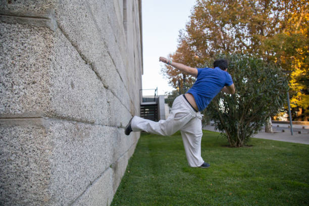 istock Young man doing an amazing parkour trick by making a turn on a wall 932416496