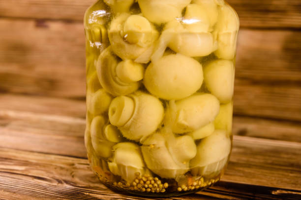istock Jar with canned mushrooms on wooden table 932416914