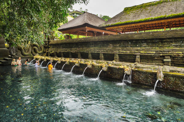 Tirta Empul temple is a Hindu Balinese water temple located near the town of Tampaksiring, Bali, Indonesia. People in the image are visitors of the temple to wash themselves in holy water.