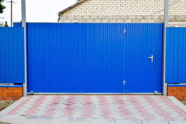 istock Fence and gate from sheets of blue corrugated metal. 932428752