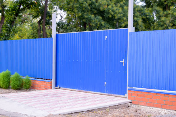 istock Fence and gate from sheets of blue corrugated metal. 932428760