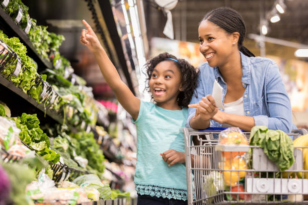 istock Elementary age girl shopping with her beautiful mom 932439944