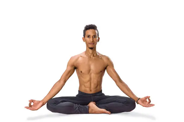 Young man meditating in Lotus position isolated on white background