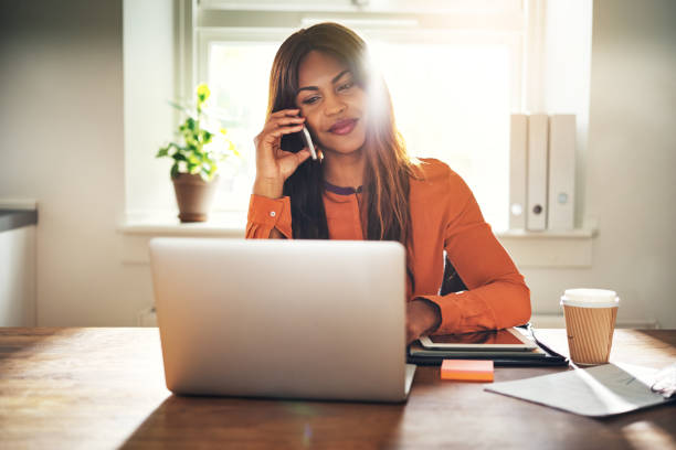 istock Smiling entrepreneur working from home and talking on a cellphone 932458574