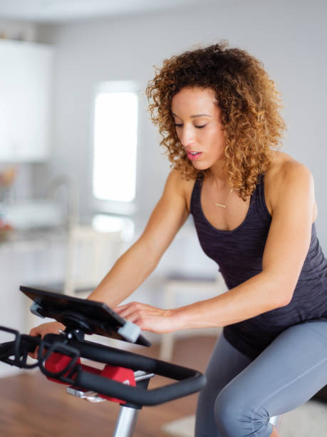 istock Woman Exercising on exercise bike in Home 932459192