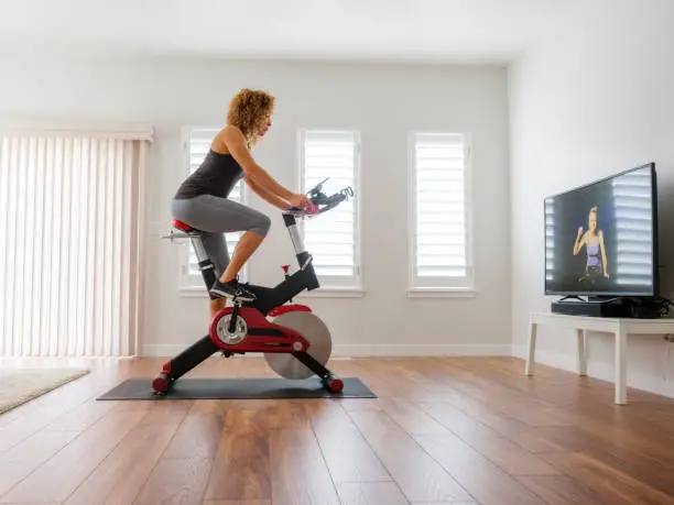 Photo of Woman Exercising on Spin Bike in Home