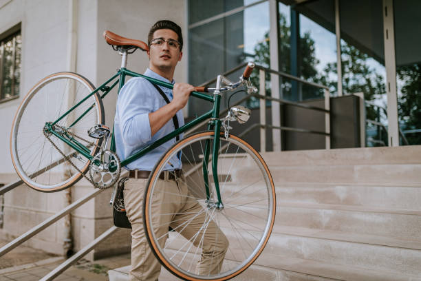 istock Handsome businessman carrying his bicycle 932459354