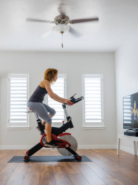 istock Woman Exercising on exercise bike in Home 932459478