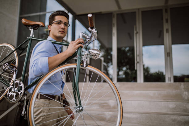 istock Handsome businessman carrying his bicycle 932463212
