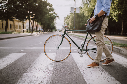 Handsome young businessman with bicycle in the city