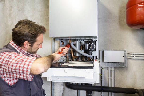 istock plumber repairing a condensing boiler 932472492