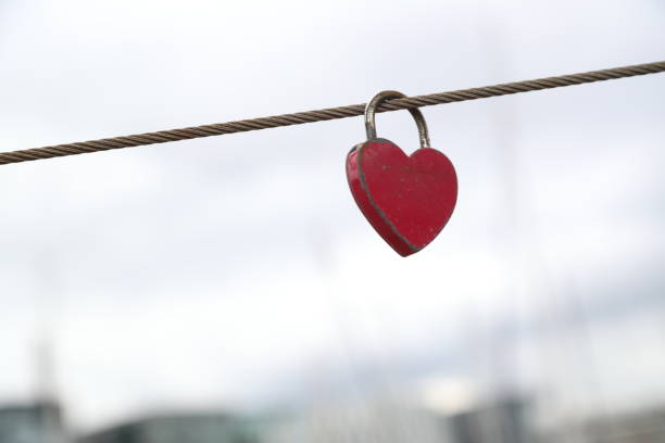 istock Low Angle View Of Heart Shape Padlock Attached To Metallic Cable 932476910