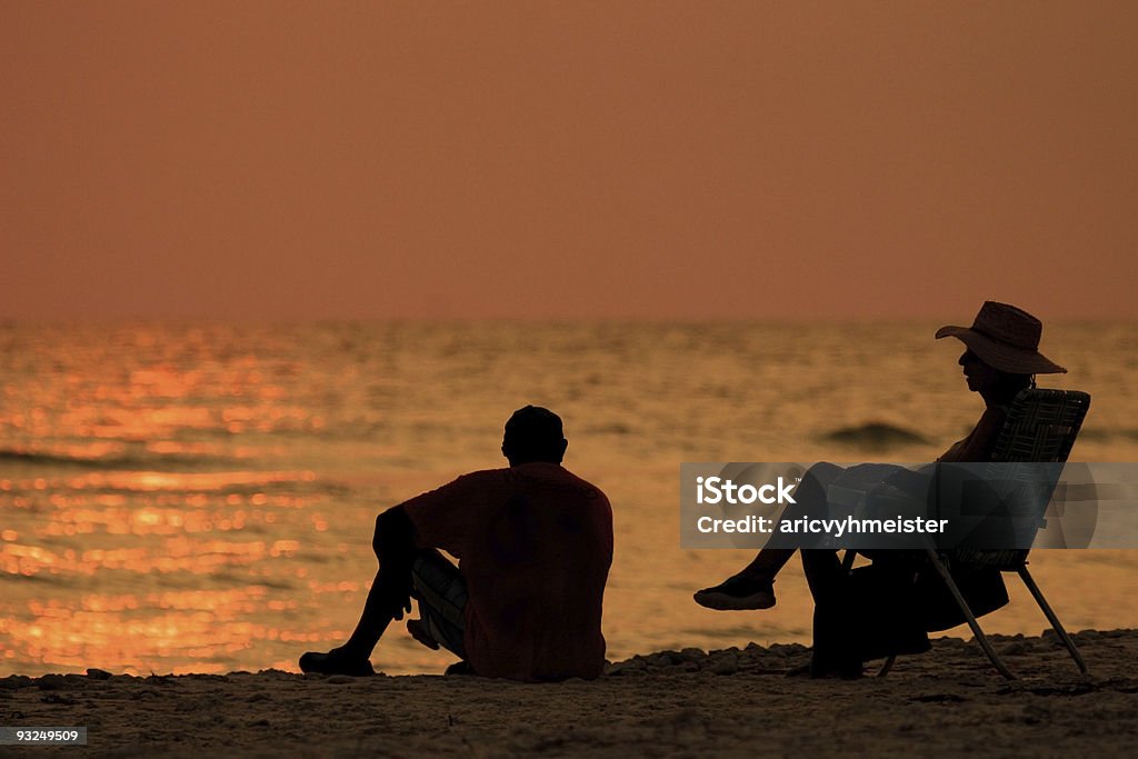 Пара, сидящая на пляже - Стоковые фото Люди роялти-фри