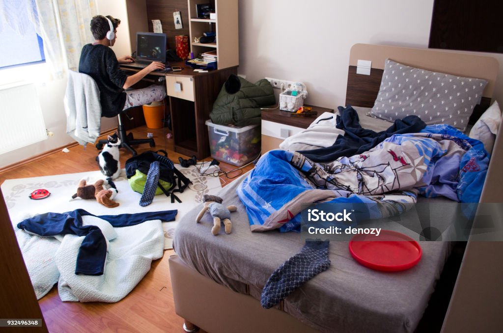 Teenagers messy room Teenager is chatting on laptop in his untidy room Messy Stock Photo