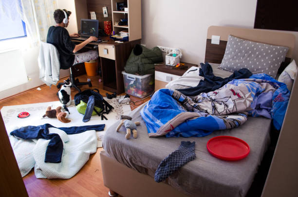 Teenagers messy room Teenager is chatting on laptop in his untidy room headphones plugged in photos stock pictures, royalty-free photos & images