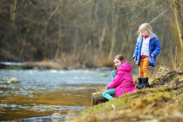 istock Two cute little sisters having fun by a river 932502786
