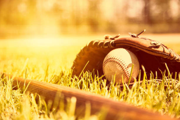 istock Baseball season is here.  Bat, glove and ball on field. 932514700