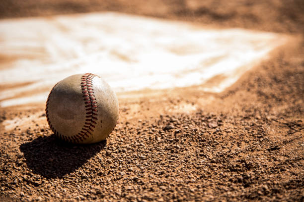 istock Baseball season is here.  Weathered ball on home plate. 932515032