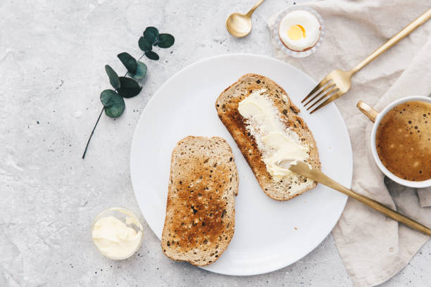flat lay fetta di pane tostato imburrato bianco su un piatto. concetto di colazione - butter margarine fat bread foto e immagini stock
