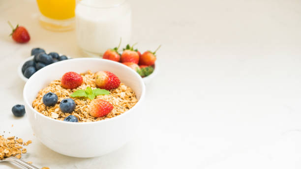 istock Breakfast Cereal By Juice Glass In Bowl On White Background 932525924