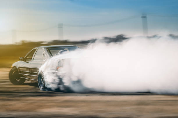 istock Blurred Motion Of Car Emitting Smoke Against Sky 932533578
