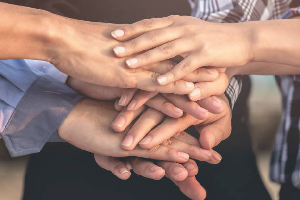 istock Midsection Of Business Colleagues Stacking Hands 932533612