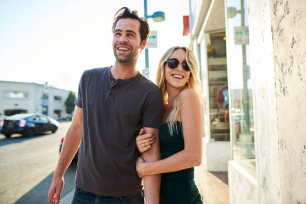 istock flirty couple having fun walking together down street 932534052