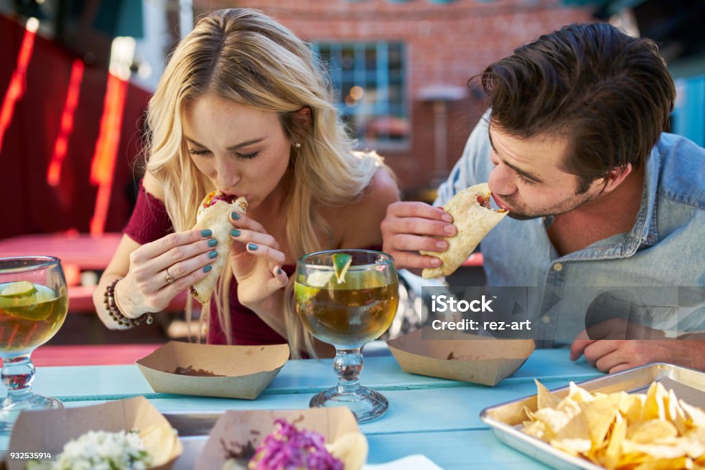 coppia romantica mangiare tacos strada al ristorante messicano all'aperto - Foto stock royalty-free di Taco