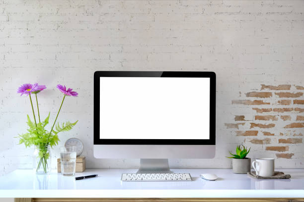 istock Mockup desktop Blank screen modern computer, coffee mug, house plant, bouquet and office supplies. 932541910