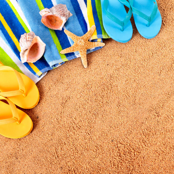 istock Beach background with towel, starfish and flip flops square format 932543622
