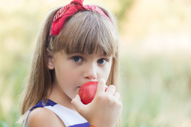 istock Happy girl  eating an apple 932546554