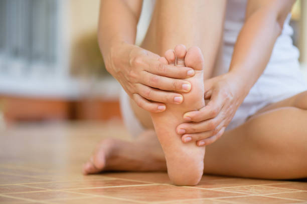 giovane donna da vicino che prova dolore al piede a casa. assistenza sanitaria e concetto medico. - on foot foto e immagini stock