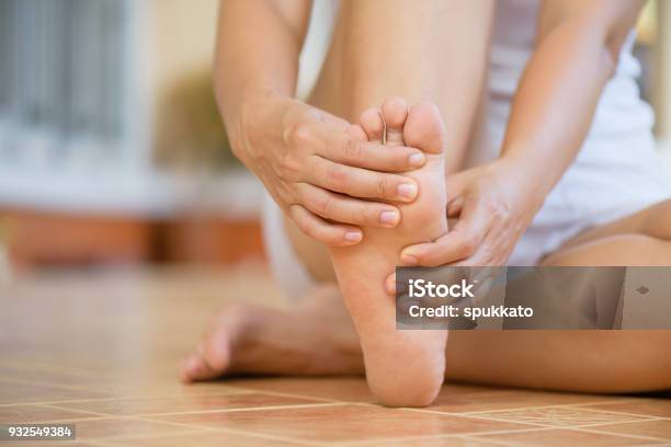 Closeup Young Woman Feeling Pain In Her Foot At Home Healthcare And Medical Concept Stock Photo - Download Image Now