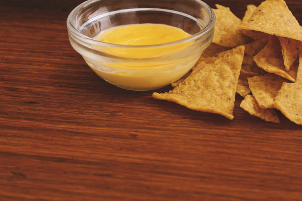 istock Close up view of nachos with cheese dip 932552204