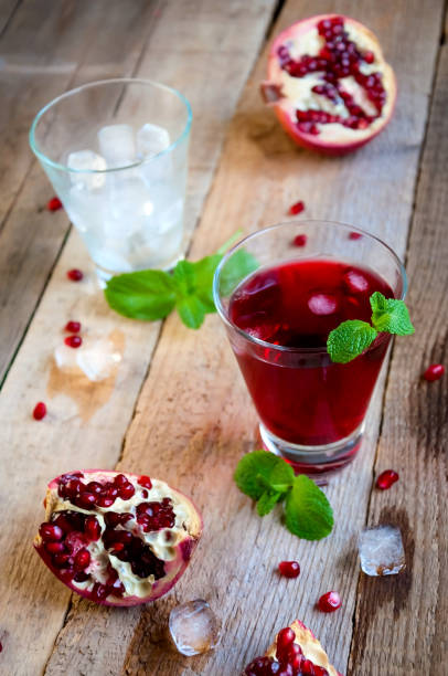 istock Pomegranate Cocktail with Ice Mint and Fruit on Wooden Table. Refreshing Summer Drink Soft or Alcoholic 932552386