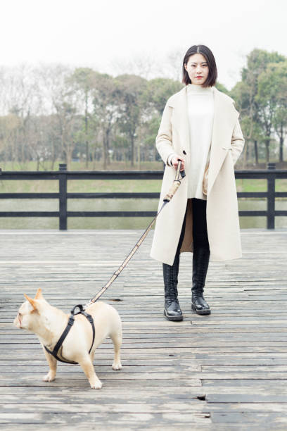 istock young woman walking her dog in park 932557144