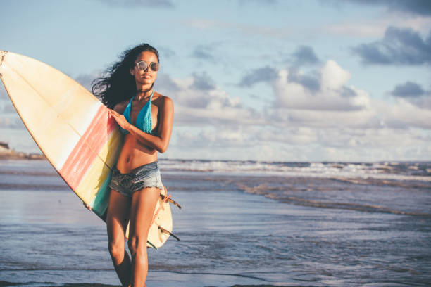 istock Surfer woman carrying surfboard 932564854