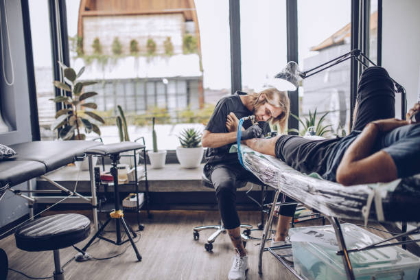 istock Young artist making tattoo on a leg 932572850