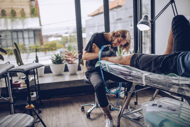 istock Young man artist making tattoo 932573148