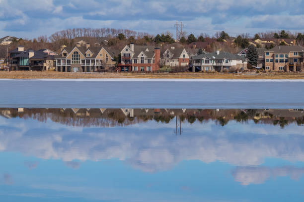 Family neighborhood by the lake View of a new neighborhood located by the lake; houses and clouds reflect in water; Colorado, USA colorado springs city stock pictures, royalty-free photos & images