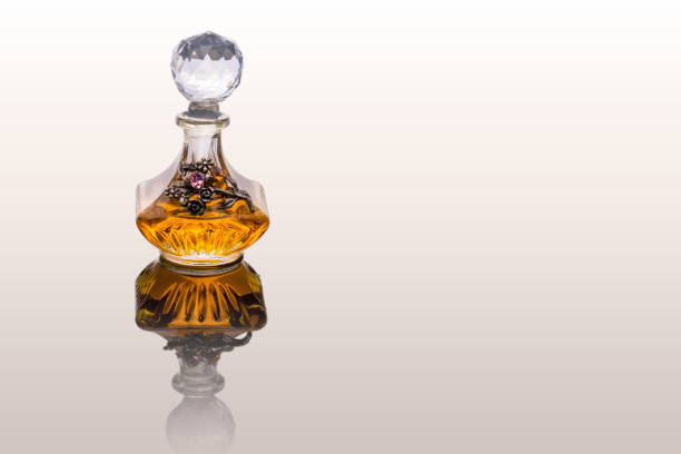 close up shot de traditionnel luxe arabe oud orange huile parfum dans a beau la main cristal verre jar bouteille transparente et pipette de verre isolé sur blanc antique style d’arrière-plan, texte espace - musc photos et images de collection