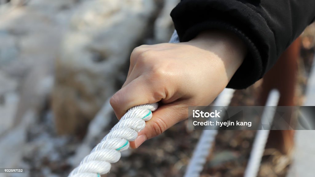 The woman's hand holding the rope. Adult Stock Photo