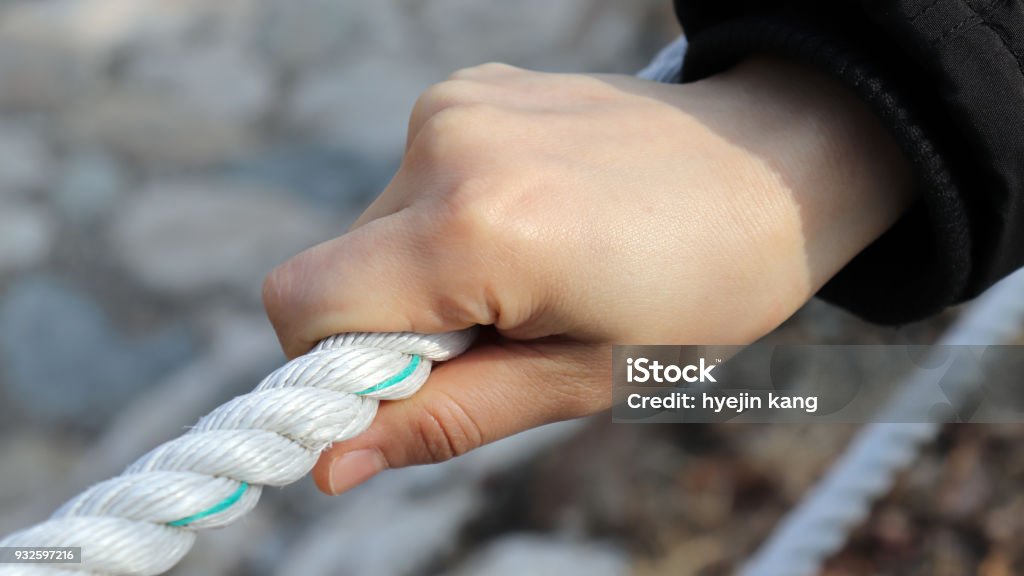 Close-up image of the woman's hand holding the rope. Adult Stock Photo