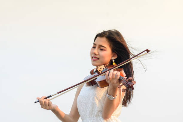 istock Happy woman playing violin on the beach. 932597372